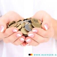 Kündigung mit Abfindung: So wirkt sich das 2026 auf Bürgergeld aus 5 Eine Person hält Münzen in seinen Händen