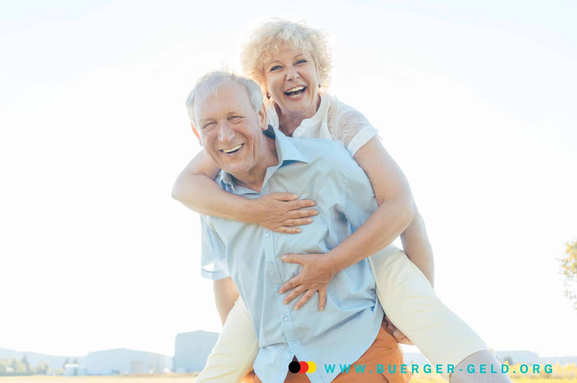 Grundsicherung im Alter Oktober 2024 - wann Auszahlung der Extra-Rente 2 Seniorin wird von Senior auf dem Rücken getragen