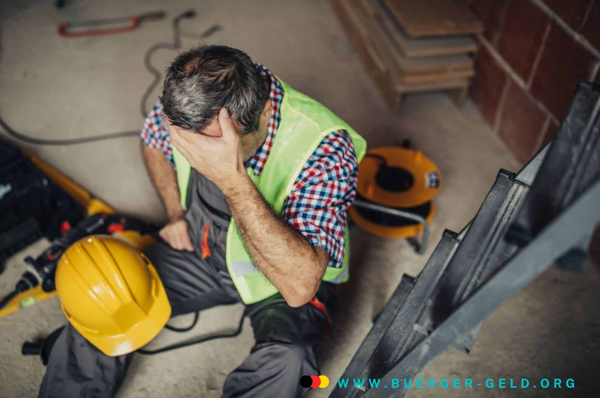 Bürgergeld 2025: So funktionieren Aufstockung und Einkommensanrechnung für Arbeitnehmer und Selbstständige 2 Arbeiter mit Helm sitzt auf dem Boden und hält sich die Stirn