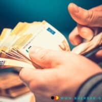 Steuerentlastungen: Wer profitiert am meisten von den neuen Freibeträgen? 5 Eine Person die ein Bündel Geld in der Hand zählt