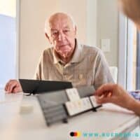 Renteneintrittsalter: Wer kann wann in Rente gehen - große Tabelle! 5 Ältere mann schaut auf Kalender mit der Hand einer Frau