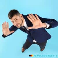 Verzicht auf Bürgergeld unwirksam, wenn Einkommensberechnung umgangen wird 4 Mann im Anzug hebt abwehrend die Hände