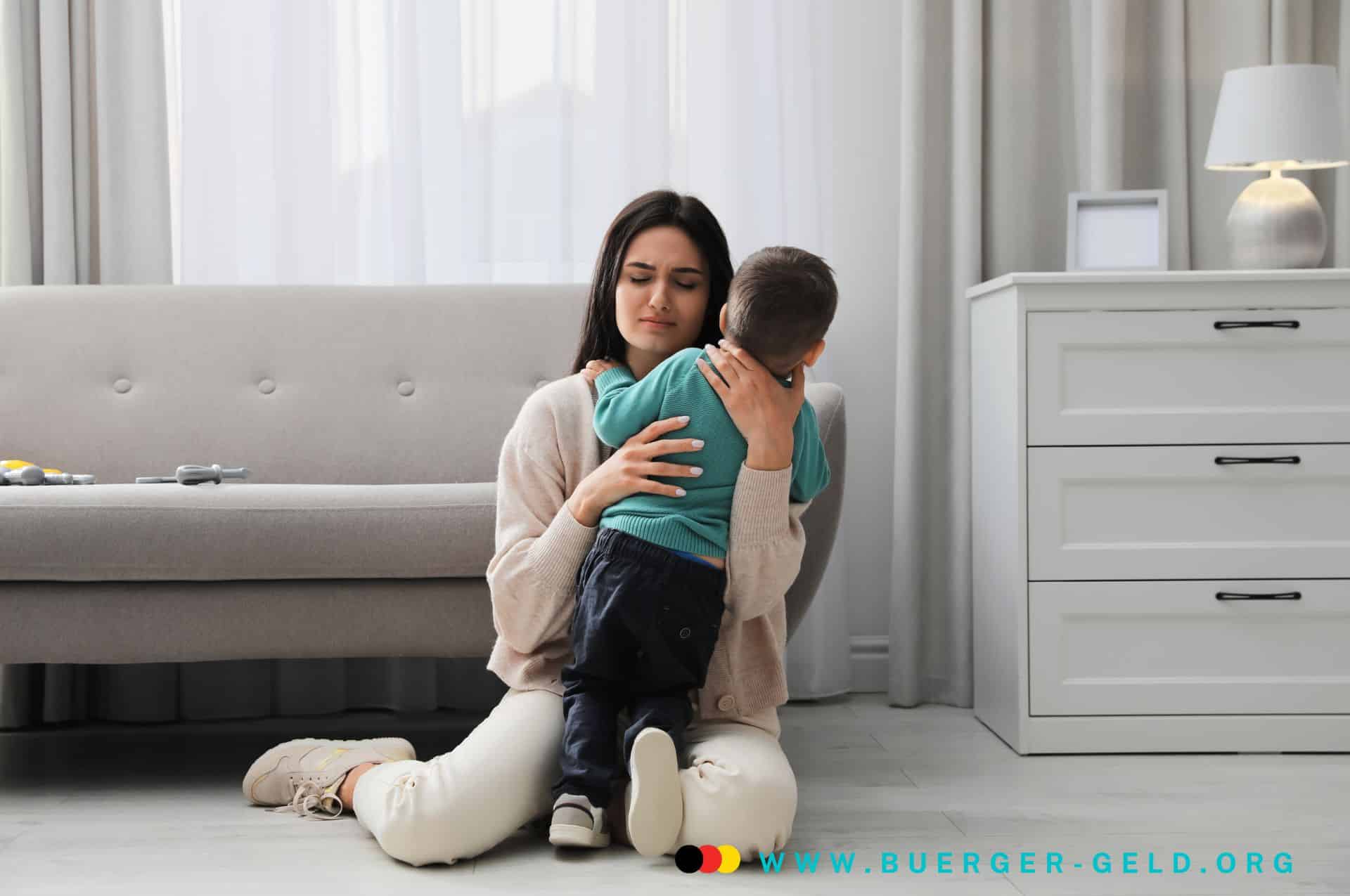 buergergeld mehrbedarf alleinerziehend mit kindern Mutter tröstet Kind und hält es im Arm