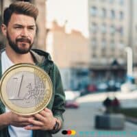 Bürgergeld: wie viel zahlt das Jobcenter für Alleinstehende? 5 Mann hält große ein Euro Münze in den Händen