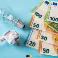 Bürgergeld 2025: Stromkosten-Krise - Regelsatz unter Druck 4 Euro Scheine neben Glühbirne und Steckerkabel