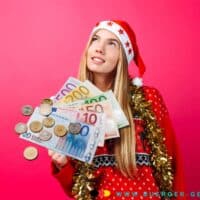 Weihnachtsgeld in der Grundsicherung - Beihilfe beim Bürgergeld? Ja und nein! 4 Frau in Weihnachtskostüm hält Geld in der Hand