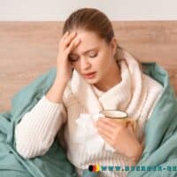 Krankenstand in Deutschland: Linke fordert mehr Ausgleich für Arbeitnehmer 3 Eine Frau sitzt mit einer Tasse in der Hand krank im Bett.