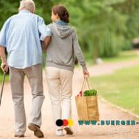 Rentenversicherung muss über Teilrente bei Pflege aktiv aufklären - Gerichtsurteil! 4 Ältere Frau hilft älterem Mann beim Laufen