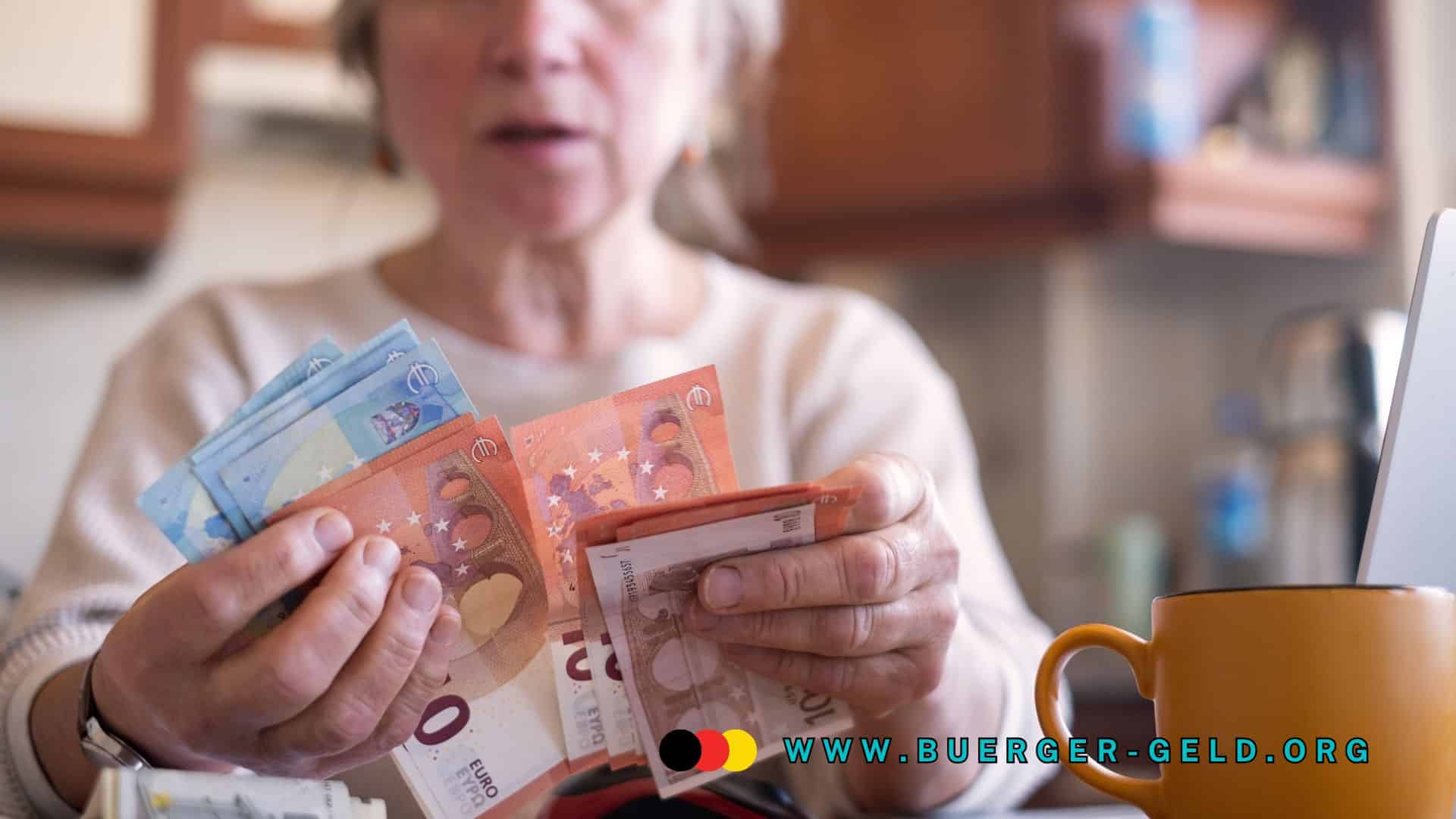 Ältere Person zählt Euro-Geldscheine in der Hand, sitzt am Tisch mit Kaffeetasse und Laptop; Symbolbild für Rentner und Finanzen, www.buerger-geld.org