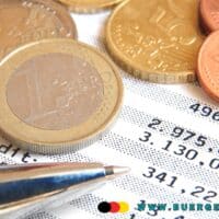 Bürgergeld – Darf das Jobcenter die Vorlage von Kontoauszügen verlangen? Für welchen Zeitraum? 5 Kontoauszug mit Kugelschreiben und Euromünzen