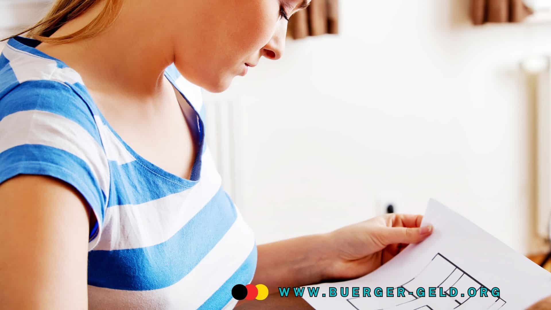 Junge Frau im blau-weiß gestreiften T-Shirt betrachtet einen Wohnungsgrundriss auf Papier in heller Wohnung.