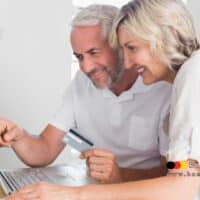 Rentenzuschlag: Nachzahlung zur Rente und Umstellung der Zahlung im Dezember 2025 4 Älteres Paar prüft am Laptop seine Renteneinnahmen mit Kreditkarte, im Vordergrund auffällig Euro-Scheine, unten rechts Logo von Bürger & Geld – Symbolbild zur Rentenerhöhung und Nachzahlung 2025.