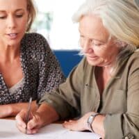 Mehr Geld vom Rententräger: Diese 5 Formulare lohnen sich 4 Zwei Frauen füllen gemeinsam Rentenanträge am Tisch aus und beraten sich bei der Altersvorsorge, unterstützt vom Magazin Bürger & Geld.