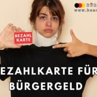 Bürgergeld als Bezahlkarte? Wie Hamburg jetzt die Auszahlung verändert 5 Eine Person hält eine rote Karte mit der Aufschrift "Bezahlkarte" in der einen Hand und zeigt mit der anderen Hand darauf. Im Hintergrund ist ein neutraler, beigefarbener Raum. Im oberen Bereich steht das Logo und die Webadresse von "Bürger & Geld". Darunter ist in großer, weißer Schrift der Text "Bezahlkarte für Bürgergeld" zu sehen.