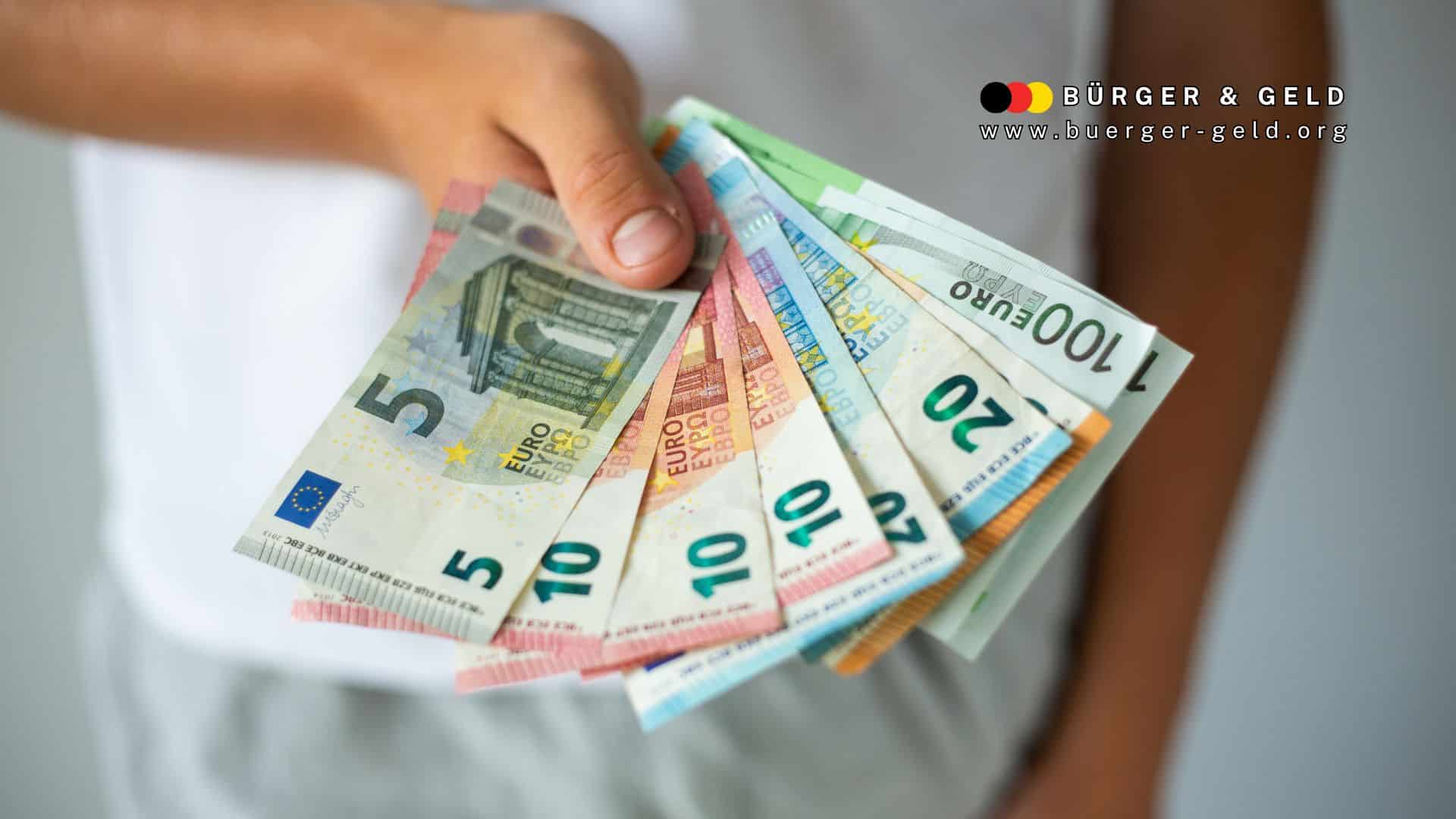 Eine Hand hält mehrere Euro-Geldscheine (5, 10, 20, 50, 100 Euro) fächerförmig, Symbolbild für Rentenlücken durch lange Schul- und Studienzeiten sowie freiwillige Beitragsnachzahlung zur gesetzlichen Rentenversicherung bis zum 45. Lebensjahr, mit Logo von Bürger & Geld – Nachrichtenmagazin des Vereins Für soziales Leben e. V.