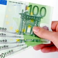 Mehr Netto 2025: Kommt die Steuerentlastung noch dieses Jahr 4 Hand hält mehrere 100-Euro-Scheine: Symbolbild für steuerfreie Überstundenzuschläge und mehr Netto durch Steuerentlastung 2025.