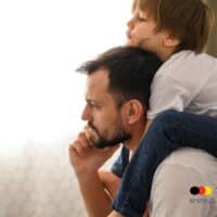 Mütterrente und Co: Wer profitiert wirklich von staatlichen Leistungen – auch Väter, Adoptiv- und Pflegeeltern? 5 Ein Vater trägt sein Kind auf den Schultern und schaut nachdenklich.