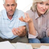 Rente und Scheidung: Wie werden die Rentenpunkte beim Versorgungsausgleich verteilt? 4 Seniorenpaar mit Rentenunterlagen diskutiert über Versorgungsausgleich und Aufteilung der Rente bei Scheidung, Symbolfoto für finanzielle Unsicherheit im Alter.