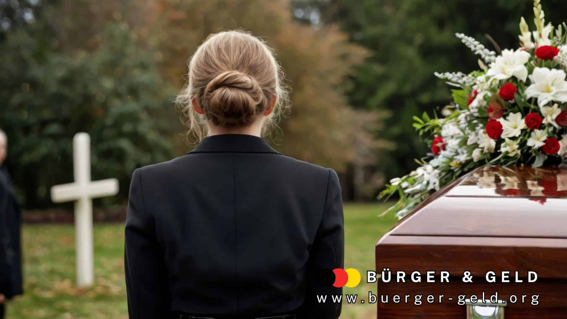 Eine Frau in schwarzer Trauerkleidung steht bei einer Beerdigung vor einem geschlossenen Sarg mit Blumenarrangement. Im Hintergrund ist ein weißes Holzkreuz zu sehen. Im Bild unten rechts befindet sich das Logo von BÜRGER & GELD sowie die Website-Adresse www.buerger-geld.org.