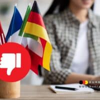 Bürgergeld-Informationen der Arbeitsagentur künftig nur noch auf Deutsch – Folgen, Fakten und Experten-Einschätzung 4 ausländische Fahnen auf Schreibtisch, Symbol Daumen nach unten
