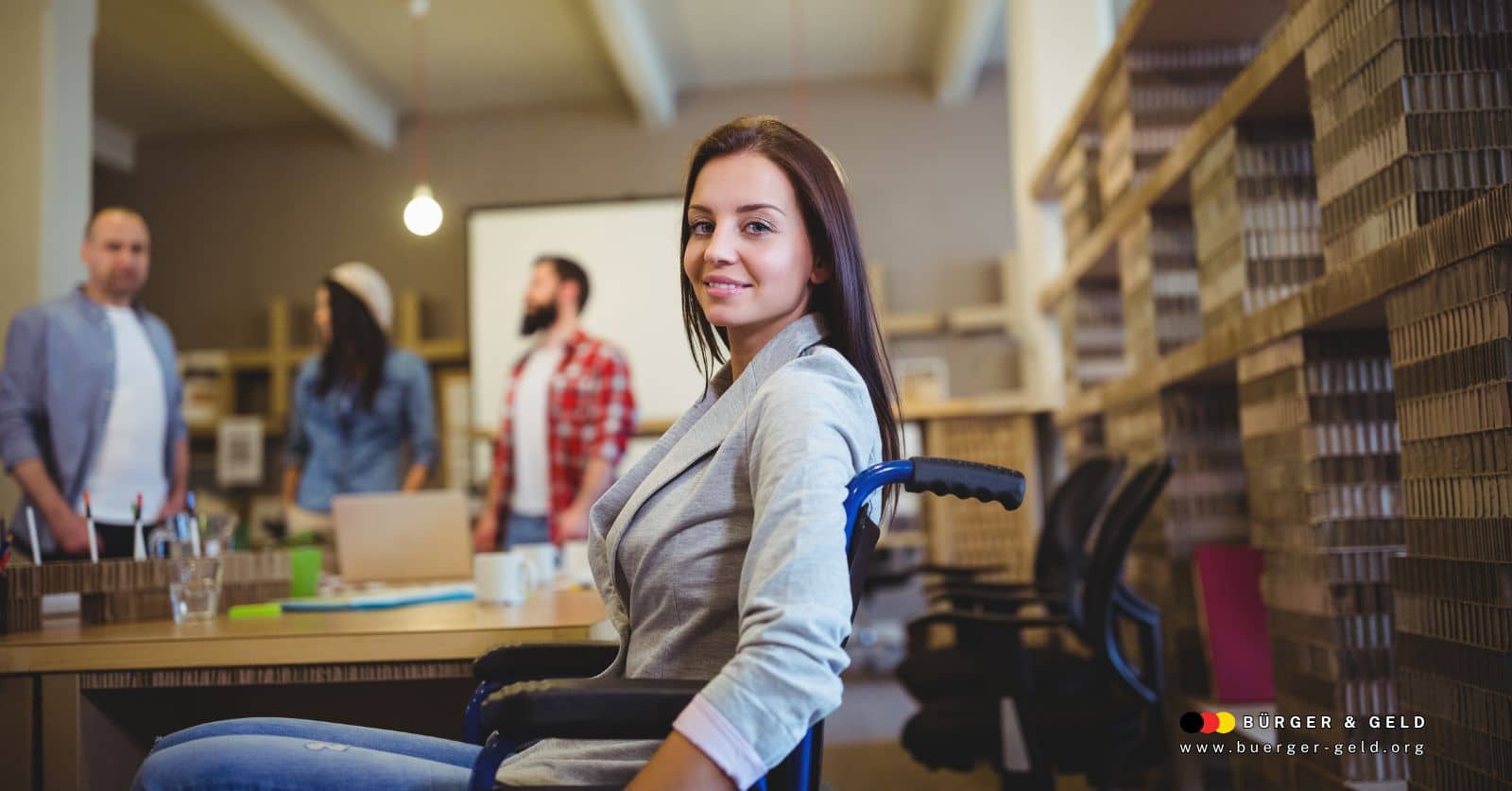 Arbeitsassistenz unterstützt Frau im Rollstuhl am modernen Arbeitsplatz – Symbol für Integrationshilfen für Menschen mit Behinderung