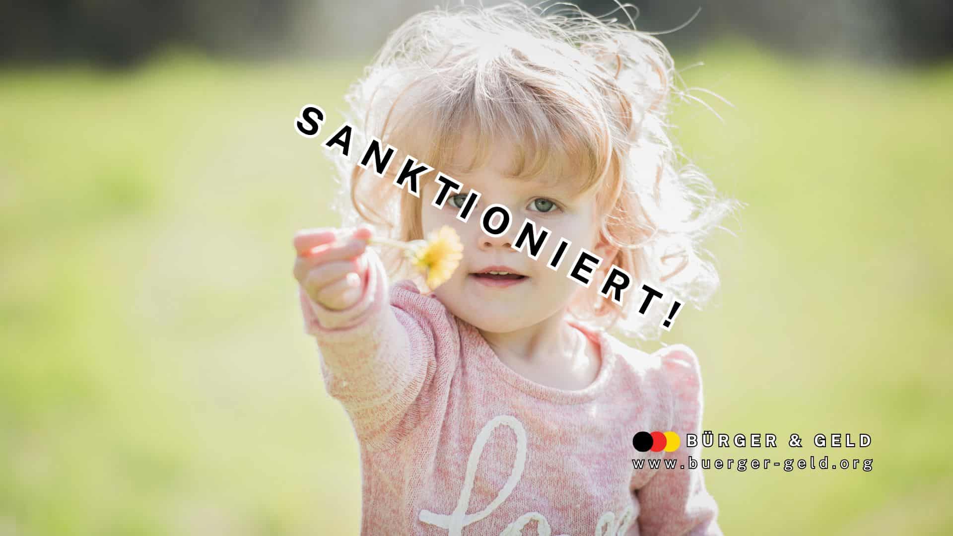 Kleines Kind hält Blume auf Wiese hoch