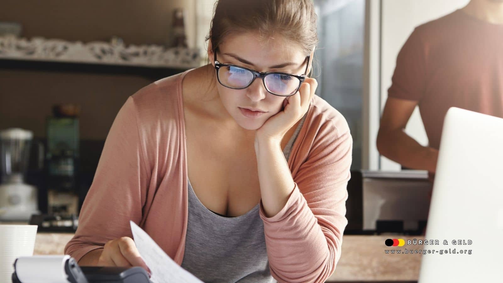 Eine Frau sitzt nachdenklich am Schreibtisch und betrachtet Unterlagen zur Rentenberechnung. Im Vordergrund liegt ein Taschenrechner, im Hintergrund erkennt man einen Mann und eine Küche. Das Logo von Bürger & Geld ist unten rechts eingeblendet.