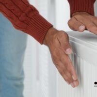 Heizen wird 2026 deutlich teurer – was Rentner jetzt wissen müssen 5 Rentner prüft Heizkörper zuhause – steigende Heizkosten durch höhere CO₂-Steuer ab 2026, Bürger & Geld