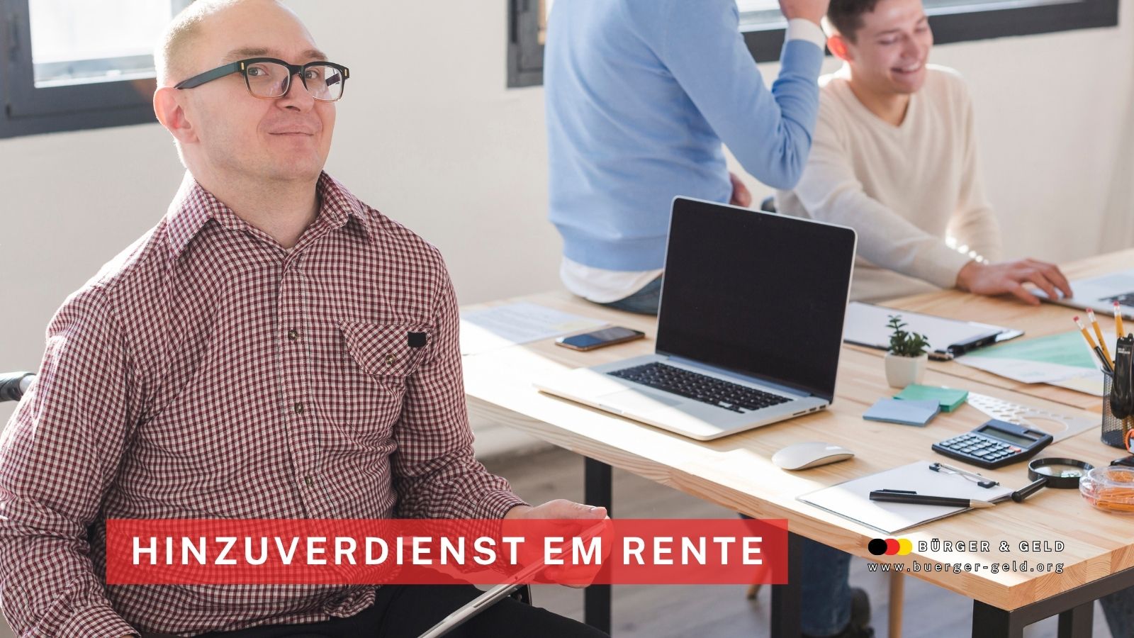 Ein Mann im Rollstuhl sitzt an einem Schreibtisch in einem modernen Büro. Im Hintergrund arbeiten zwei Kollegen an Laptops. Auf dem Bild steht der Text „Hinzuverdienst EM Rente“. Rechts unten ist das Logo von Bürger & Geld und die Internetadresse zu sehen.