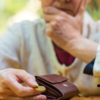 Rentenauszahlung im November 2025: Wenn jeder Euro zählt 4 Ältere Frau schaut nachdenklich auf ihren Geldbeutel, hält eine einzelne Münze in der Hand – Symbolbild für finanzielle Sorgen von Rentnern im November 2025.