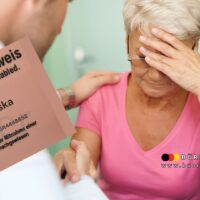 Zwei Daten, viele Fragen: Wenn der Schwerbehindertenausweis früher geprüft wird, als er gilt 5 Eine Frau mit besorgtem Gesichtsausdruck hält ihren neuen Schwerbehindertenausweis, während sie von einer Sozialberaterin beruhigend am Arm berührt wird. Symbolbild zur Unsicherheit bei befristeter Schwerbehinderung und Überprüfungsterminen.