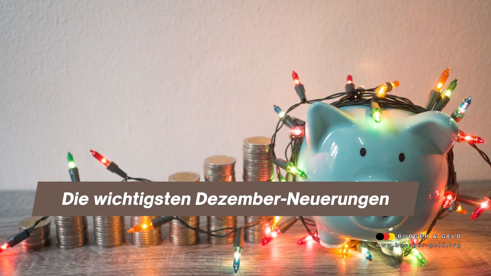 Sparschwein mit Weihnachts-Lichterkette vor gestapelten Münzen – Symbol für die wichtigsten finanziellen Dezember-Neuerungen bei Nebenkosten, Rente, Bahn und Sozialleistungen.