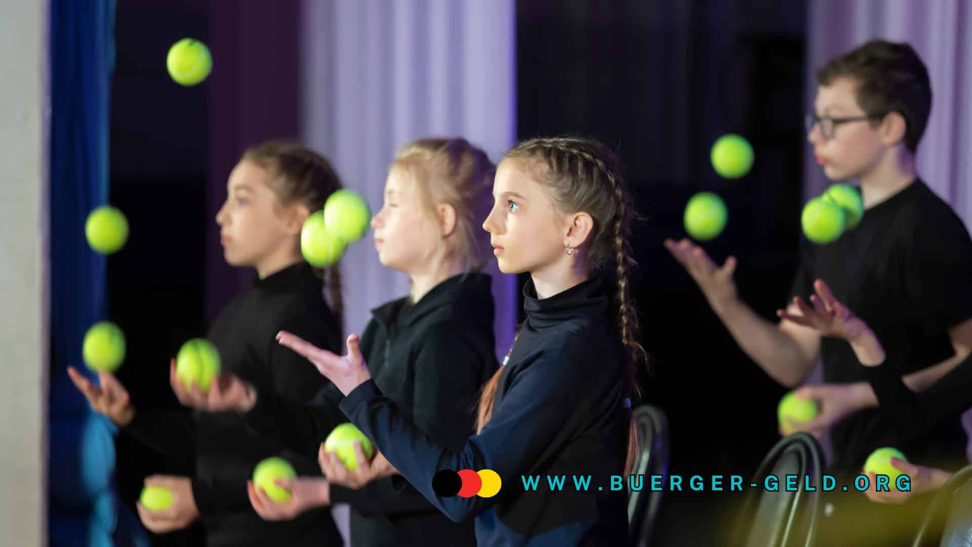 vier Kinder jonglieren mit Tennisbällen