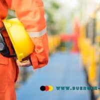 Arbeiter ausschnittweise mit Helm unter dem Arm