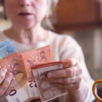 Seniorin zählt Euro-Geldscheine in der Küche, Thema Rente, Wohngeld oder Grundsicherung, Bürger & Geld Magazin