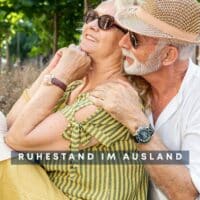 Älteres Paar genießt entspannt den Ruhestand im Ausland auf einer sonnigen Parkbank – Symbolbild für Lebensqualität und Vielfalt im Alter.