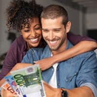 Ehepaar freut sich über Zuverdienstgrenzen und Einkommensfreibeträge beim Bürgergeld - mit Euros in den Händen!