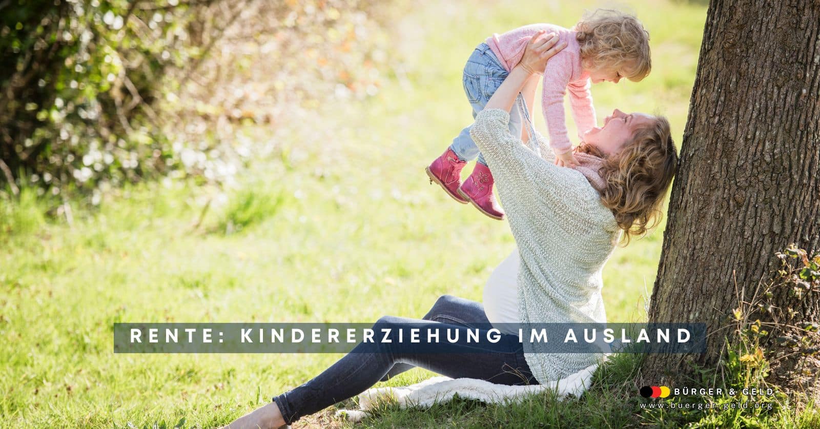 Mutter sitzt unter einem Baum mit ihrem Kind auf dem Arm, im europäischen Ausland!