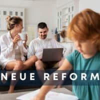 Familie sitzt gemeinsam im Wohnzimmer, bespricht am Laptop die neue Sozialreform zu Wohngeld und Kinderzuschlag
