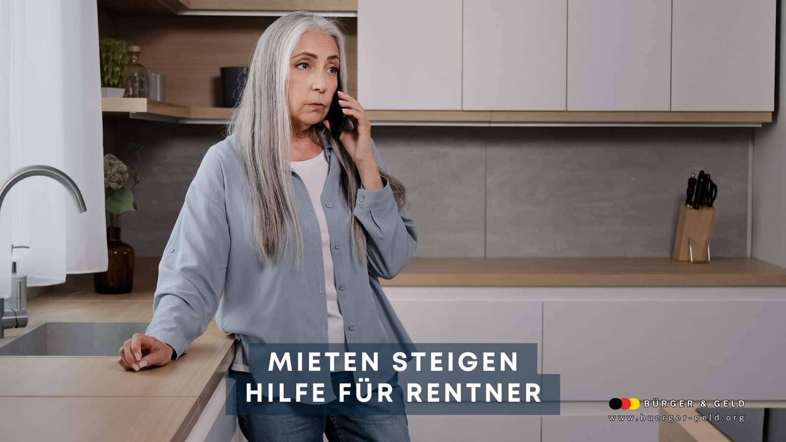 Ältere Frau mit langen grauen Haaren telefoniert in moderner Küche – Thema steigende Mietpreise und Hilfen für Rentner in Deutschland.