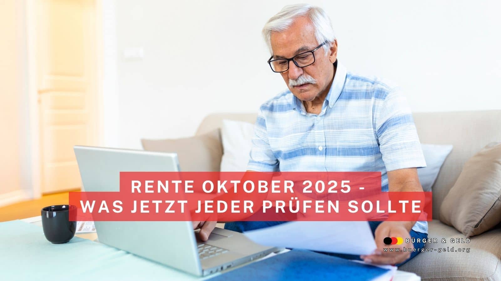 Älterer Mann sitzt zuhause mit Laptop und Papieren am Tisch, prüft seine Rentenzahlung für Oktober 2025; vorne im Bild ist eine Tasse zu sehen.