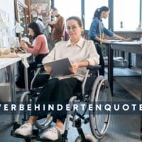 Mitarbeiterin im Rollstuhl arbeitet mit Tablet in einem modernen Kreativbüro, mehrere Kolleginnen und Kollegen nähen und arbeiten im Hintergrund – Symbolbild für Inklusion und Schwerbehindertenquote 2025 in Unternehmen.
