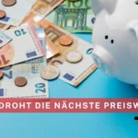 in weißes Sparschwein steht auf einem Tisch, umgeben von verschiedenen Euro-Geldscheinen und Münzen. Im Vordergrund ist ein rot hinterlegter Schriftzug „2026 droht die nächste Preiswelle“, unten rechts das Logo von Bürger & Geld mit Website-Adresse.