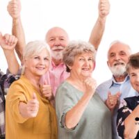 Glückliche Seniorinnen und Senioren zeigen Daumen hoch – Rentenerhöhung 2026 sorgt für Freude, Symbolbild für steigende Renten in Deutschland.