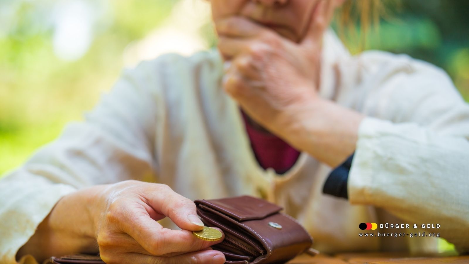 Ältere Frau schaut nachdenklich auf ihren Geldbeutel, hält eine einzelne Münze in der Hand – Symbolbild für finanzielle Sorgen von Rentnern im November 2025.