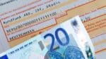 Überweisungsformular für den Rundfunkbeitrag (ARD, ZDF, Deutschlandradio) mit sichtbar ausgefüllter IBAN und einem zwanzig Euro-Schein davor als Symbol für die Zahlungsweise.