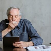 Älterer Mann liest Informationen zur steuerlichen Behandlung der Aktivrente 2026 auf einem Tablet, Bürger & Geld Nachrichtenmagazin