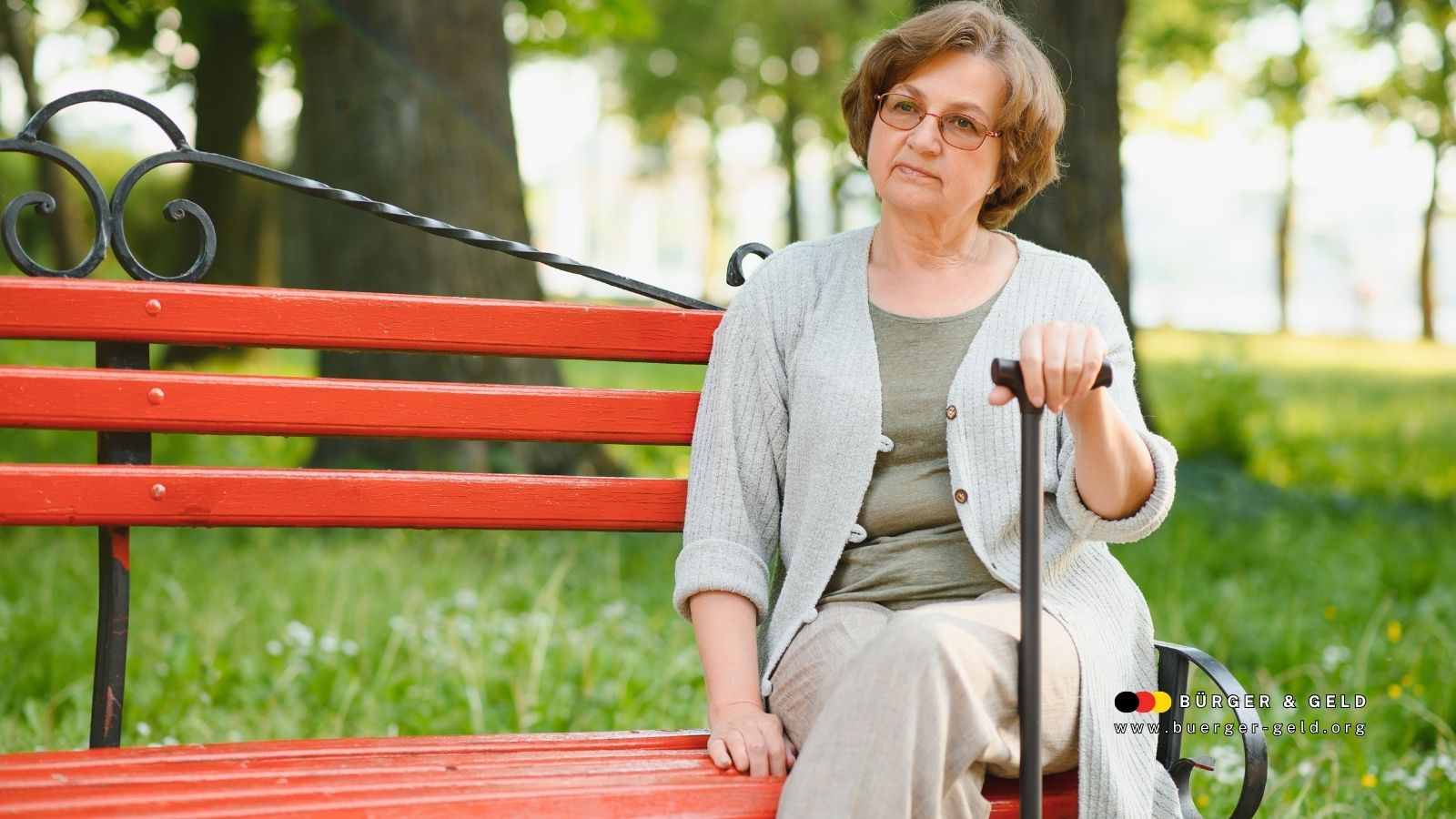 Ältere Frau sitzt nachdenklich auf einer Parkbank mit Gehstock – Symbolbild für Streit um Spätehenklausel und Hinterbliebenenrenten.