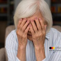 Ältere Frau mit weißen Haaren hält sich entsetzt das Gesicht vor den Augen – symbolische Darstellung für Betrugsopfer von Rentenversicherungstrickbetrug in Deutschland.