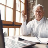 Aktivrente 2026: Wer profitiert wirklich vom Steuerbonus – und warum viele Rentner leer ausgehen 5 Älterer Mann im weißen Hemd diskutiert am Laptop über Steuerungerechtigkeit der Aktivrente 2026 – Bürger & Geld Nachrichtenmagazin